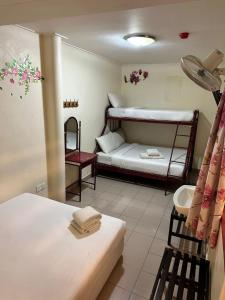 a room with two bunk beds and a bathroom at Hotel BB Inn @ Cameron in Cameron Highlands
