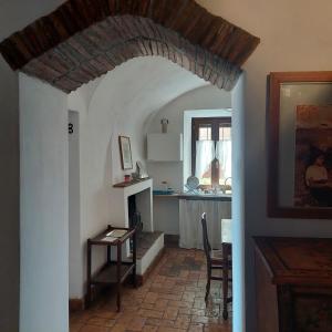 ein Wohnzimmer mit einem Tisch und einer Küche in der Unterkunft Casa Vacanze Heliae in Castel SantʼElia