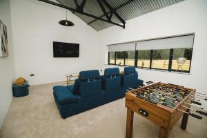 Tunstead的住宿－Sandy Barn *BRAND NEW* Barn Conversion，带沙发和桌上足球的客厅