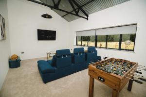 a living room with a couch and a foosball table at Sandy Barn *BRAND NEW* Barn Conversion in Tunstead