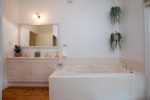 un bagno bianco con vasca e lavandino di The Retreat in Basket Range a Basket Range