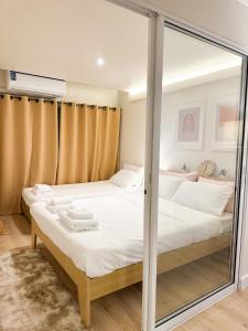 a bedroom with two beds and a glass wall at Happiness sleep C3 in Ban Bang Phang