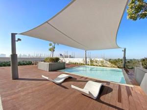 a patio with two white chairs and a swimming pool at StoneTree - Anwa By Omniyat 2BR - Luxury Apartment in Dubai