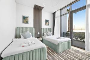 ドバイにあるStoneTree - Anwa By Omniyat 2BR - Luxury Apartmentのベッド2台と大きな窓が備わるホテルルームです。