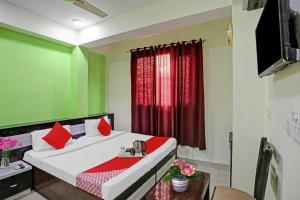 a bedroom with a bed with red and green walls at OYO Flagship 88302 Shyam Residency Near Lotus Temple in New Delhi