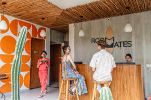 a group of people standing around a counter in a store at Roomates Beach Hostel Canggu by Ini Vie Hospitality in Canggu