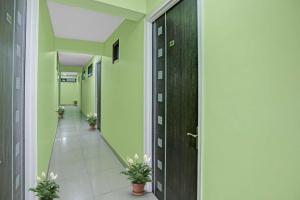 a hallway with green walls and potted plants at OYO Flagship 88302 Shyam Residency Near Lotus Temple in New Delhi