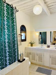 a bathroom with two sinks and a shower curtain at Casa Hera in Diani Beach