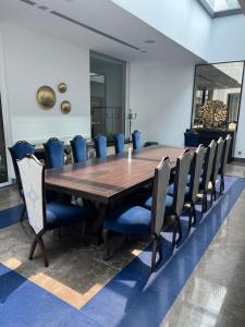 uma sala de jantar com uma mesa de madeira e cadeiras em Nurai Losin em Abu Dhabi