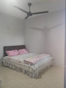 1 cama con almohadas rosas y ventilador de techo en Homestay MdmMai Private Pool, en Masjid Tanah