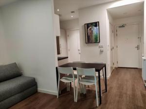 uma sala de estar com uma mesa e cadeiras e um sofá em Beautiful modern flat with 1 bedroom near Old Street Station em Londres