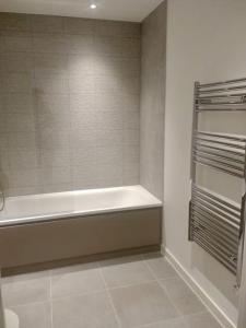 La salle de bains est pourvue d'une baignoire et d'une fenêtre. dans l'établissement Beautiful modern flat with 1 bedroom near Old Street Station, à Londres
