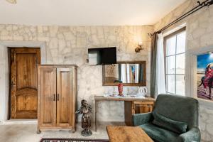 a living room with a green chair and a stone wall at Castle Panorama House in Nevsehir