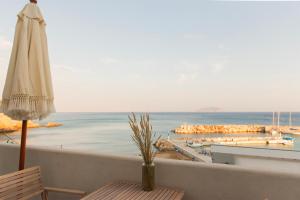 - un balcon avec un parasol offrant une vue sur l'océan dans l'établissement 64steps Studio, à Anáfi