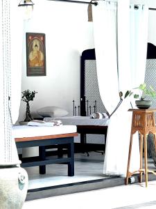 a room with a bed and a table and a window at D' Art VILLA RETREAT AND SPA in Tangalle