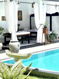 a pool with a chaise lounge next to a house at D' Art VILLA RETREAT AND SPA in Tangalle