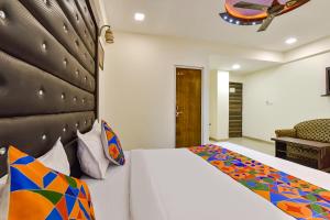um quarto com uma cama grande e um sofá em FabHotel Crystal Inn II em Ahmedabad