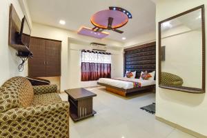 uma sala de estar com um sofá e uma cama em FabHotel Crystal Inn II em Ahmedabad