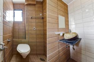 a bathroom with a toilet and a sink at FabHotel Crystal Inn II in Ahmedabad