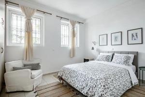 - une chambre blanche avec un lit et une chaise dans l'établissement Ένα διαμέρισμα με χαρακτήρα, à Athènes