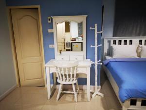 1 dormitorio con escritorio y 1 cama con espejo en Baanchomchan, en Hua Hin