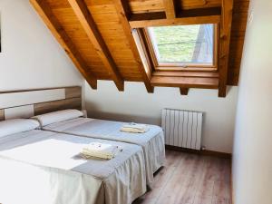 a bedroom with two beds and a window at Apartamentos Zabalarena Basoa in Orbaiceta