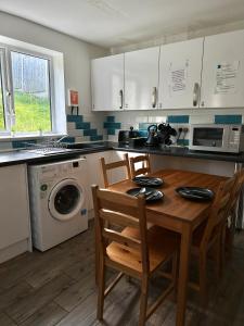 cocina con mesa, sillas y lavadora en Langdale House 5 bedroom 7 beds 3 bathrooms, en Derby