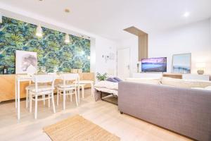 een woonkamer met een bank en een tafel met stoelen bij Villa Baturra l Centro l WiFi y Arcade in Zaragoza