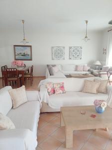 ein Wohnzimmer mit weißen Sofas und einem Tisch in der Unterkunft Zara's Home Meteora-A Home With A View! in Kalambaka