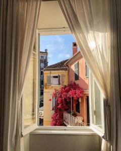a window with a view of a balcony with flowers at Luxury Villa Prada in Skriperón