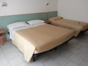 En eller flere senge i et værelse på Hotel La Parigina