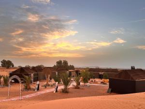 a group of houses in the middle of a desert at Sahara wellness camp in Merzouga