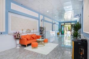un salon avec un canapé orange et une table dans l'établissement Ngọc Thị Villa, à Vung Tau