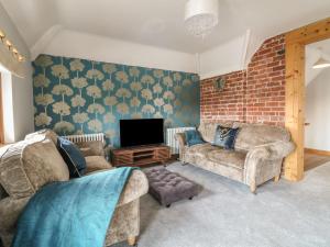 a living room with two couches and a tv at Old Print House in Ilkeston