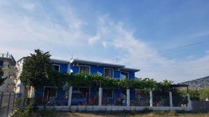a blue house with a fence in front of it at Apartments Kraja in Velipojë +70 photos