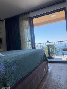 a bedroom with a bed and a large window at Reina in Petrovac na Moru