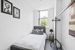 a white bedroom with a bed and a window at Luxurious 2 Bedroom Apartment with Free Parking in Chelmsford