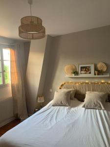ein Schlafzimmer mit einem großen weißen Bett mit zwei Kissen in der Unterkunft JO 2024 Maison avec jardin proche Paris Versailles in Saclay
