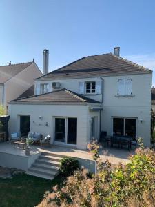 ein weißes Haus mit einer Terrasse davor in der Unterkunft JO 2024 Maison avec jardin proche Paris Versailles in Saclay
