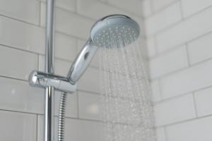 een douche met een douchekop in de badkamer bij Appartement Atmospheria in romantische stolp in Warmenhuizen