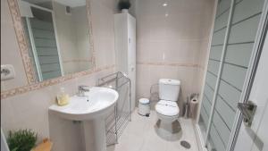 łazienka z umywalką, toaletą i lustrem w obiekcie Beachfront-Parque Paloma-Modern-Panoramic Views! w mieście Benalmádena