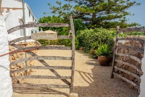 a wooden gate in front of a building at Menorca Agroturismo Llimpet in Alaior
