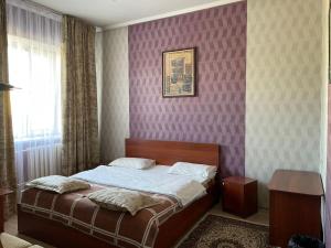 Гостиничный комплекс Жеты Казына في Zharkent: غرفة نوم بسرير في غرفة