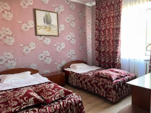 two beds in a room with pink walls at Гостиничный комплекс Жеты Казына in Zharkent