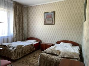 a hotel room with two beds and a window at Гостиничный комплекс Жеты Казына in Zharkent +3 photos