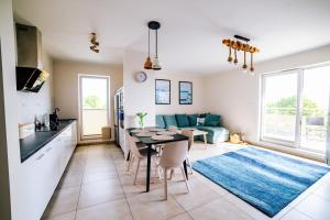 a kitchen and living room with a table and a couch at Yacht Apartments Kapitański in Wilkasy