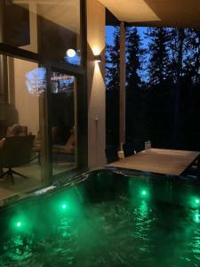 a swimming pool with green lights in a house at Havu Resort Laajavuori, a calm and peasefull place in the forest near city in Jyväskylä