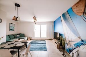 a living room with a table and a couch at Yacht Apartments Kapitański in Wilkasy