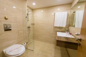 uma casa de banho com um chuveiro, um WC e um lavatório. em Grand Hotel Sunny Beach - All Inclusive em Sunny Beach