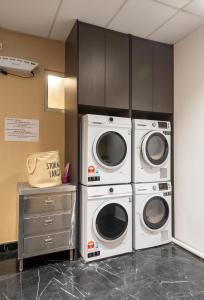 twee wasmachines en een wasmachine en droger in een kamer bij Bpod at Setapak KL in Kuala Lumpur